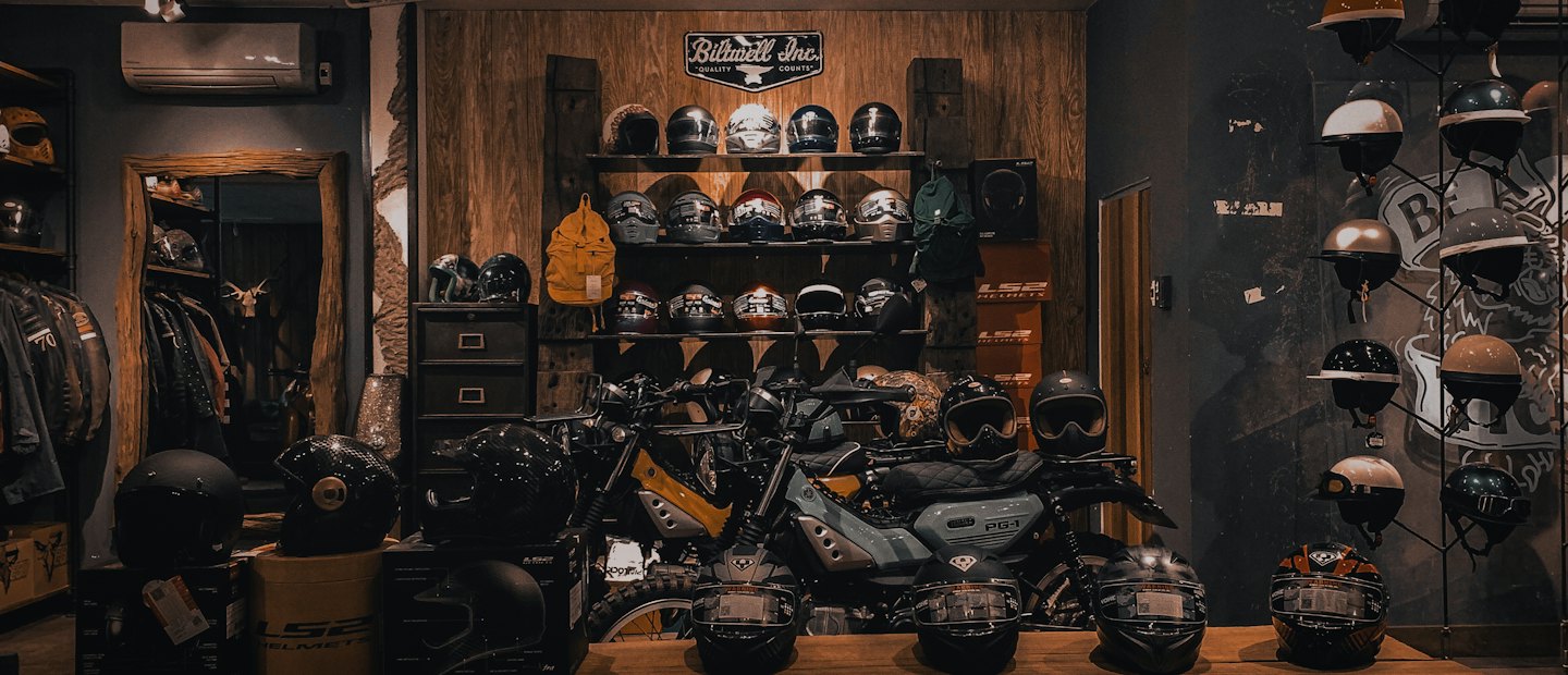 Caschi da moto e biciclette esposti in un negozio di articoli vintage.