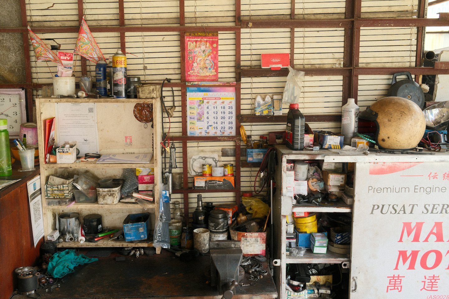 Attrezzi e pezzi di moto riempiono un'officina di riparazioni disordinata.